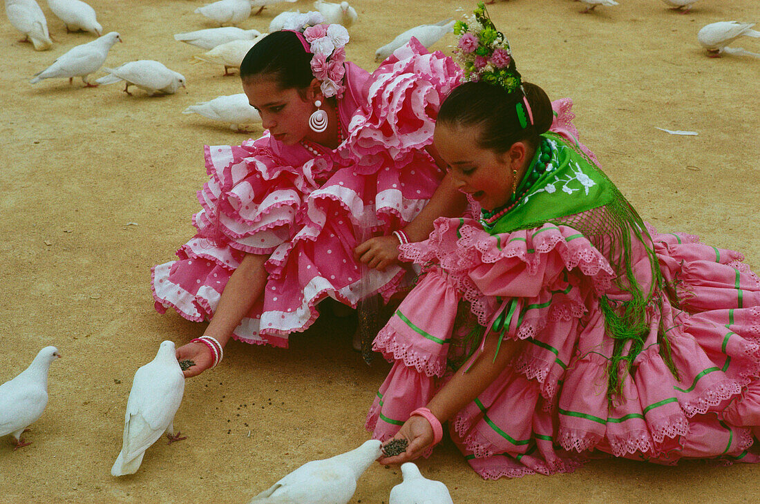 Mädchen beim Taubenfüttern,Feria de Abril,Sevilla,Andalusien,Spanien