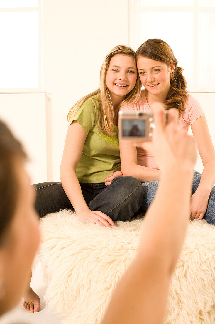 Teenage girl (14-16) taking photo of two other girls