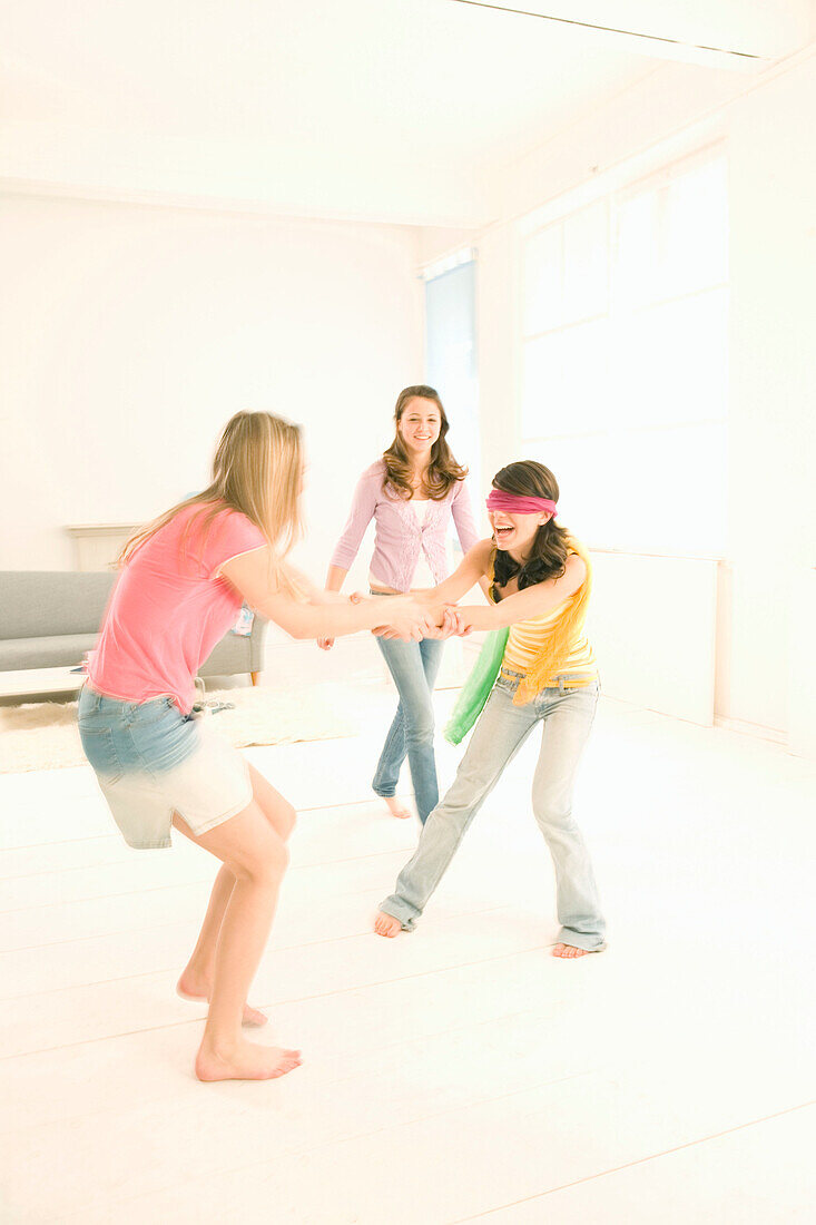 Weibliche Teenager (14-16) spielen Blindekuh