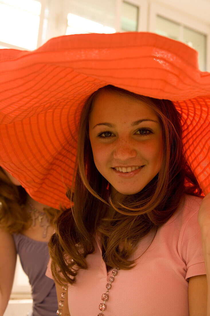 Teenage girl (14-16) smiling, wearing big hat