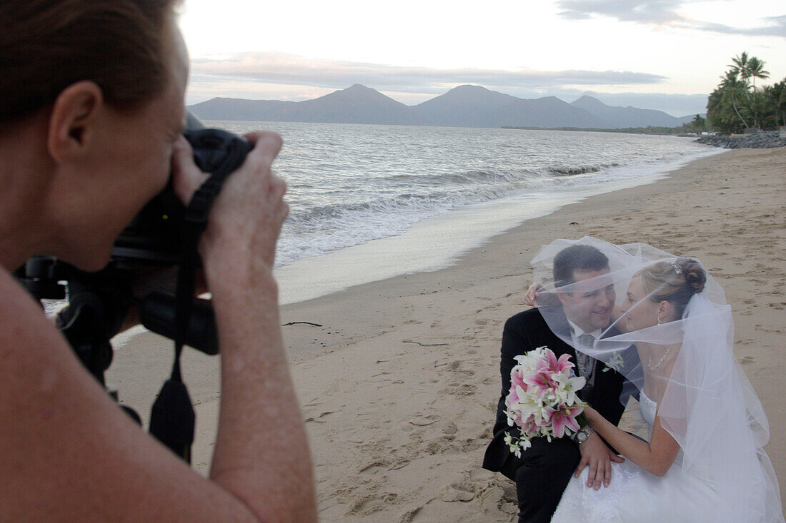 bride and groom, wedding, wedding photographer taking photos on Holloways Beach, nearby Cairns, Tropical North, Queensland, Australia