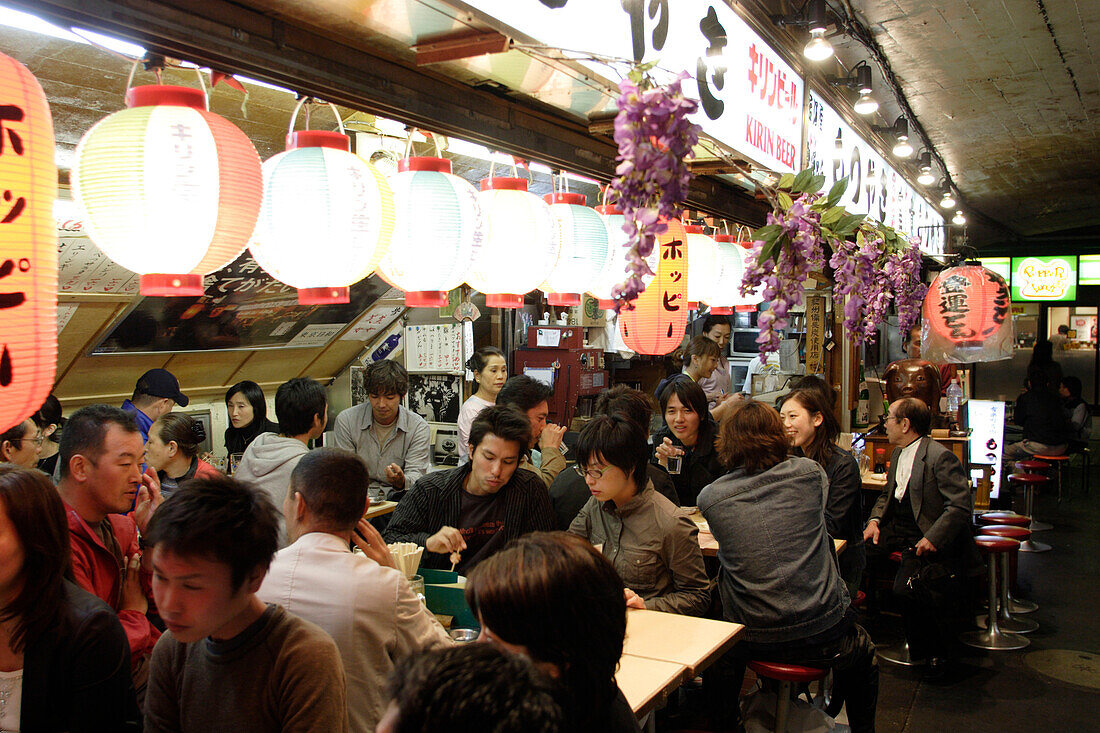 People sitting in a fast food restaurant at night, Yurakucho Yakitori Alley, Ginza, Tokyo, Japan