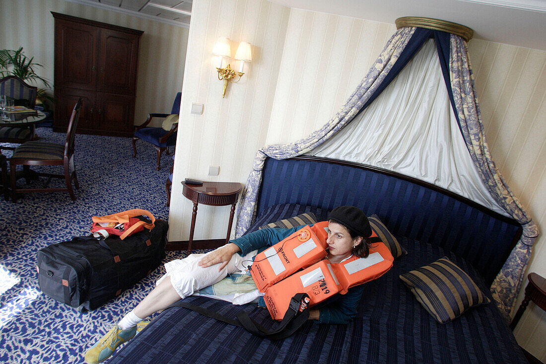 Woman with life vest in a suite, Cruise ship MS Delphin Renaissance
