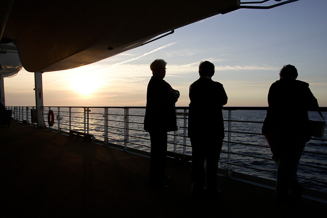 People standing at the railing at sunset, cruise ship MS Delphin Renaissance