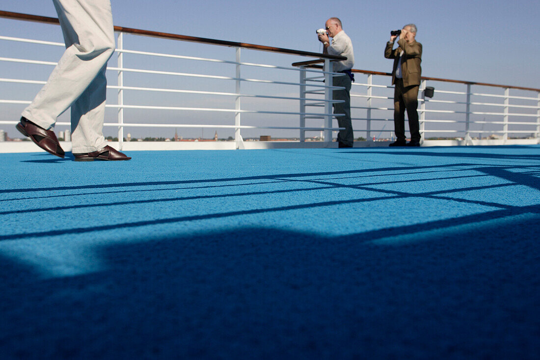 Passengers standing at the railing in the sunlight, cruise ship MS Delphin Renaissance