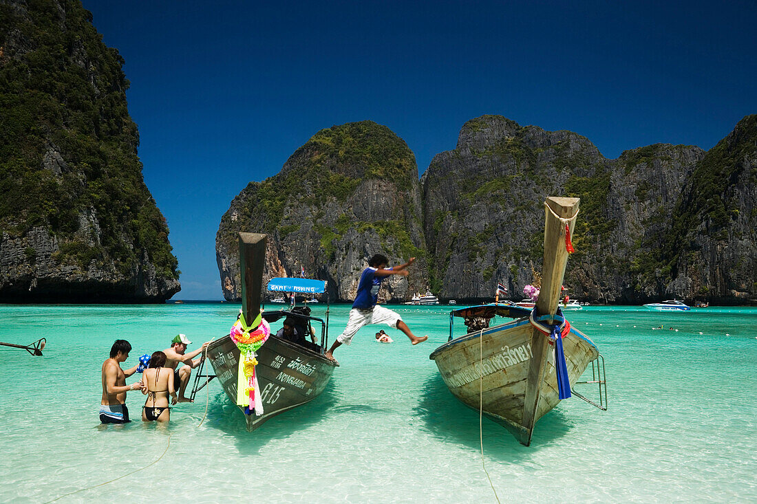 Tourists boarding long tail boat, Maya Bay, a beautiful scenic lagoon, famous for the Hollywood film "The Beach", Ko Phi-Phi Leh, Ko Phi-Phi Islands, Krabi, Thailand, after the tsunami