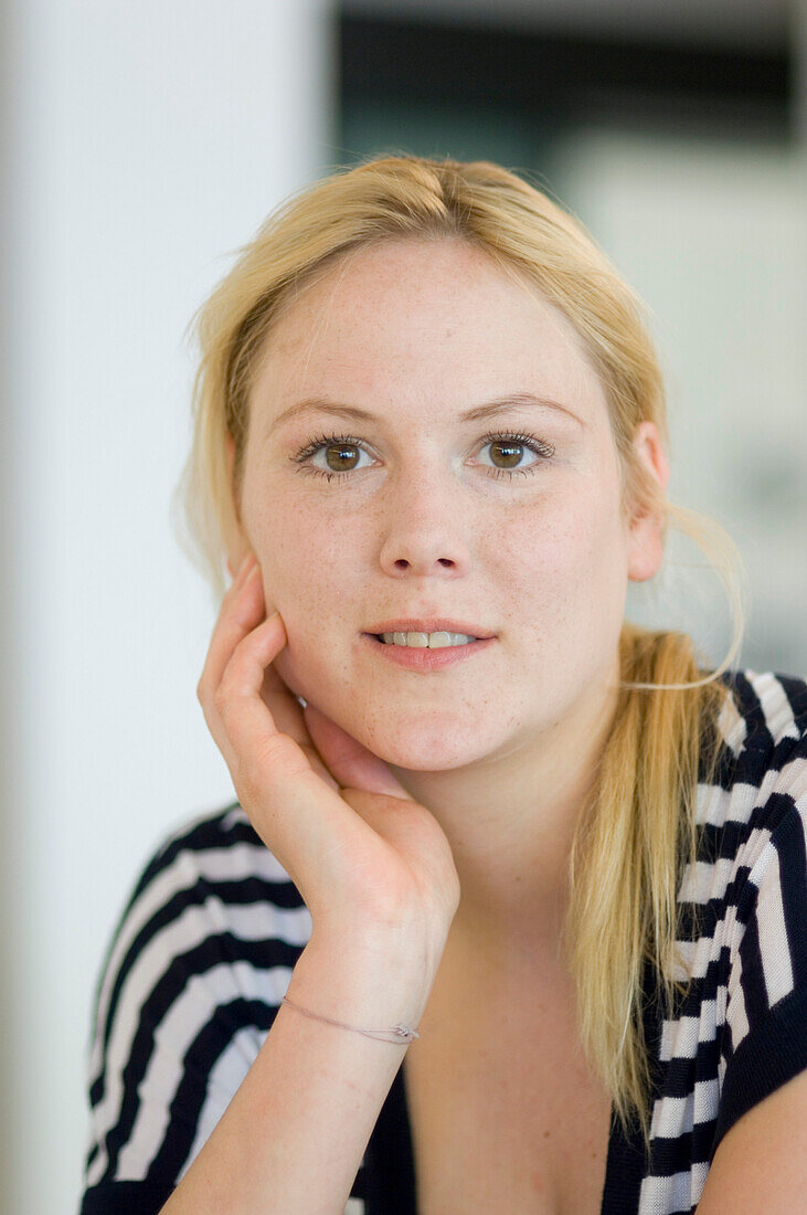 Blond woman wearing fasciated top, portrait, Germany