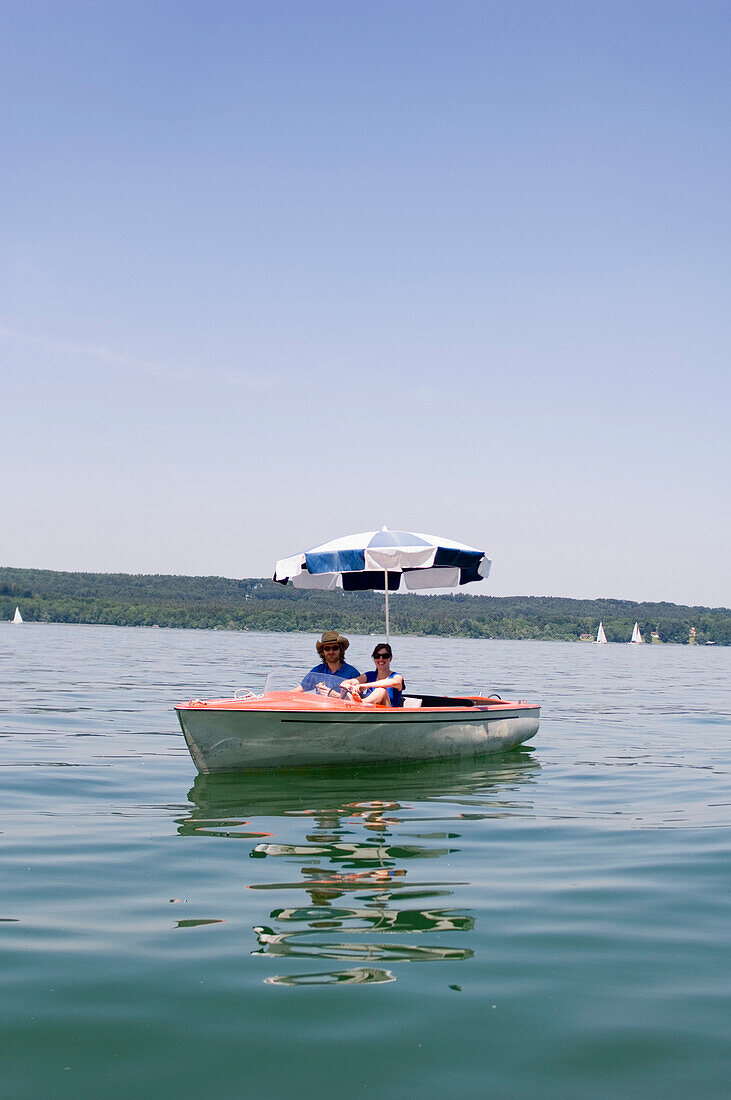 Two people in rental boat with sunshade, Starnberger See, Upper Bavaria, Germany