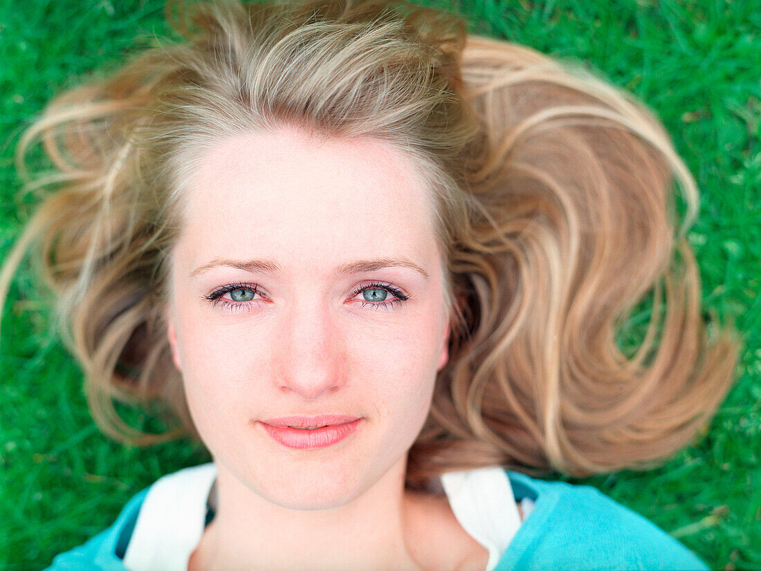 Young woman lying on grass, close-up