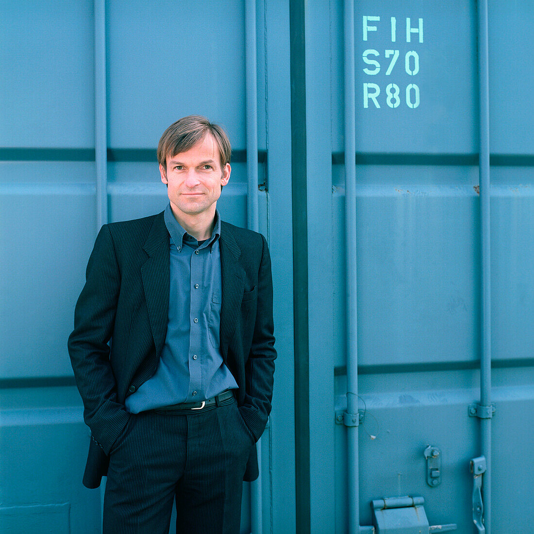 Buisnessman standing in front of a container, Germany