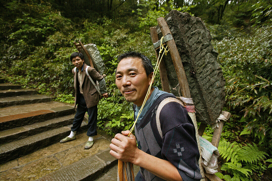 Zwei Träger tragen schwere Last auf dem Pilgerweg, Emei Shan, Provinz Sichuan, China, Asien