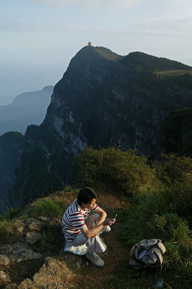 tourist with mobile phone, viewing Wan Fo Ding pagoda, tourist with mobile phone, summit of Emei Shan mountains, China, Asia, World Heritage Site, UNESCO