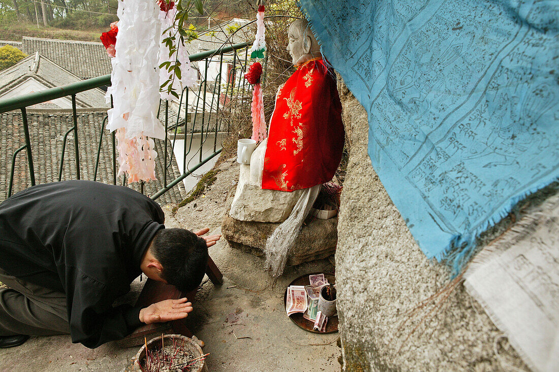 pilgrim prays in front of small statue of monk Shenizi, Nantai temple, Heng Shan south, Hunan province, Hengshan, Mount Heng, China, Asia