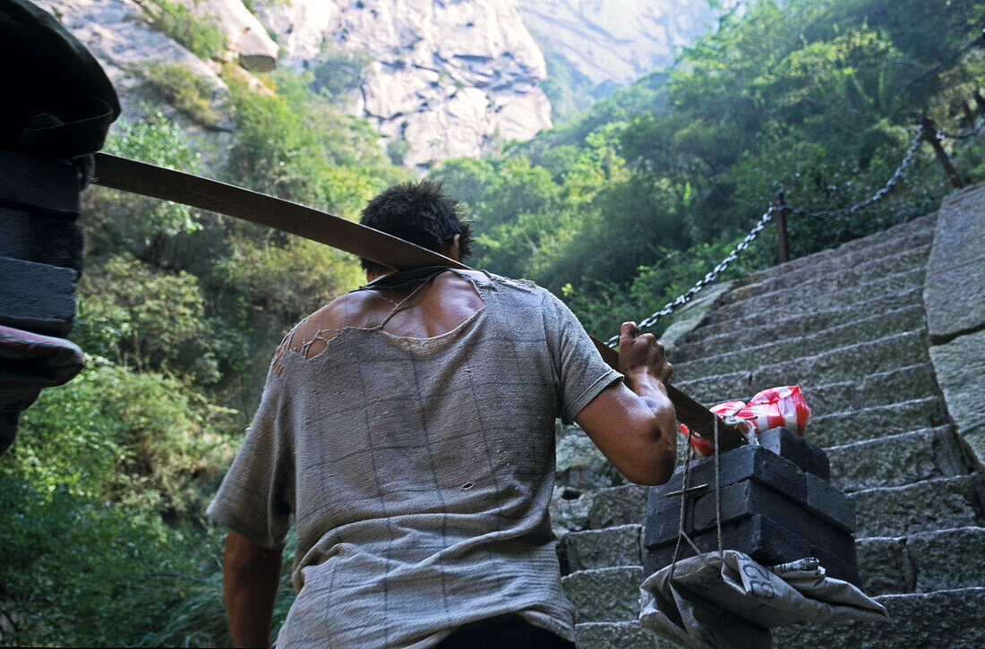 Porter carrying building material up steep mountain steps, Hua Shan, Shaanxi province, China, Asia