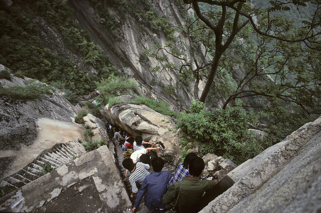 Tourists climbing downwards, stone steps and chains below North Peak,Taoist mountain, Hua Shan, Shaanxi province, Taoist mountain, China, Asia