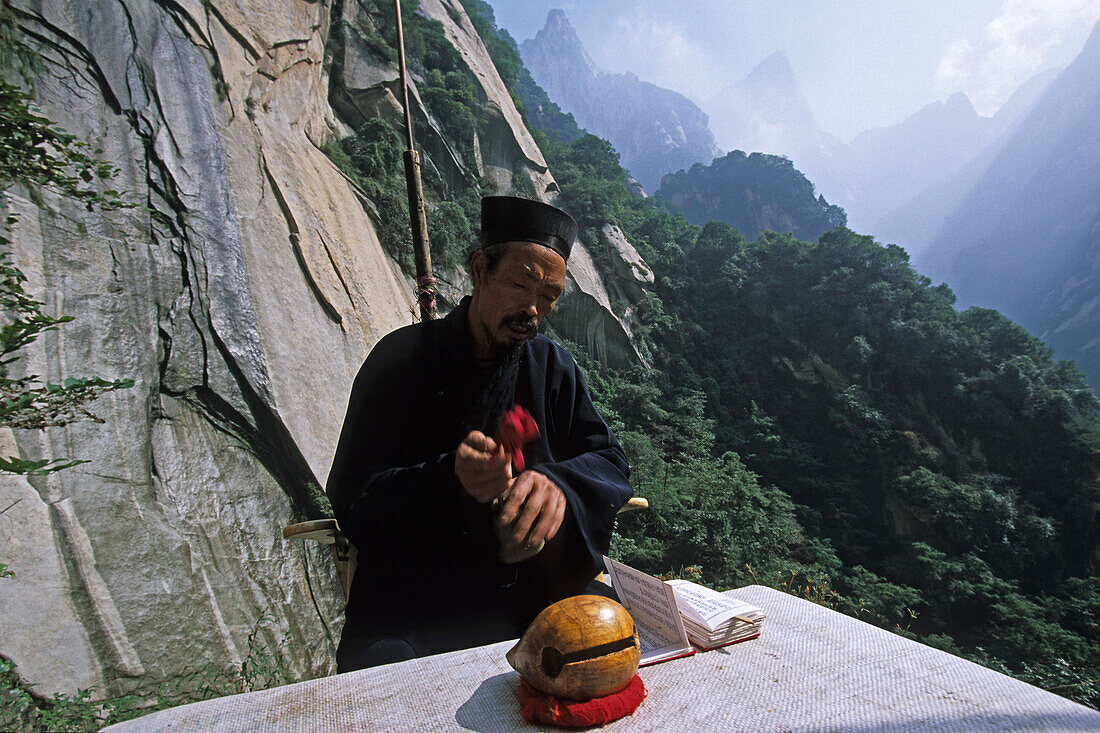 Einsiedler, Mönch, Hua Shan,Einsiedlermönch, Daoist im Gebet vor seiner kleinen Hütte in einer Steilwand, Huashan, Provinz Shaanxi, China, Asien