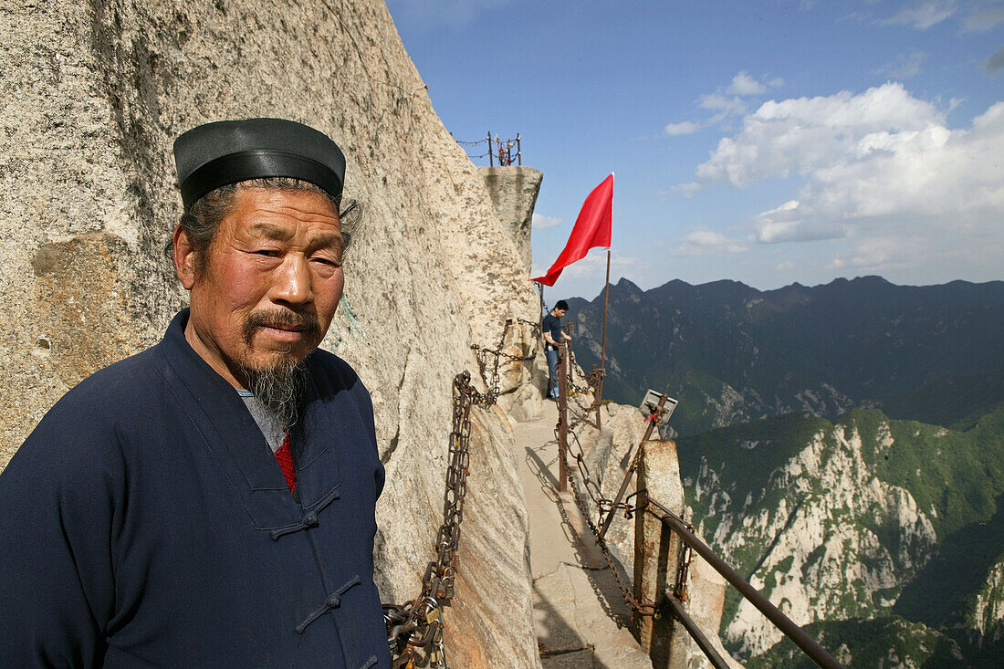 Taoist monk in front of a small cave temple, cliffs of South Peak, Hua Shan, Shaanxi province, Taoist mountain, China, Asia