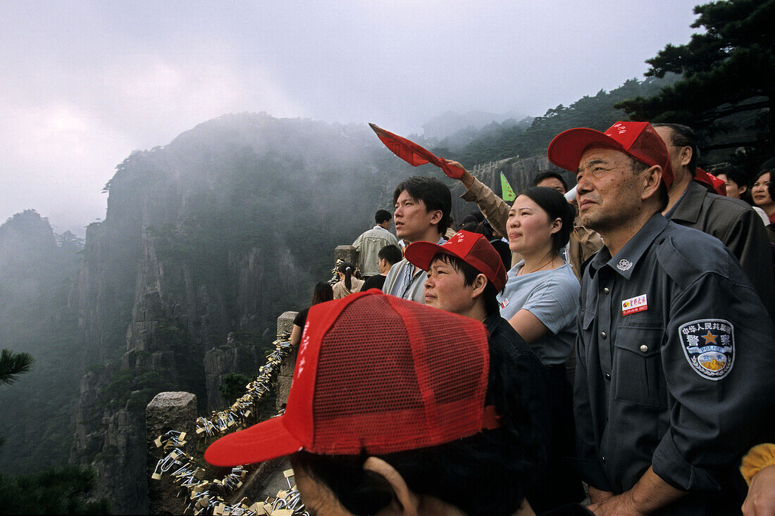 Eine Touristengruppe betrachtet die Aussicht vom Gipfel, Huang Shan, Provinz Anhui, China, Asien