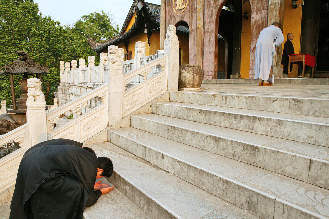 Pilger verbeugen sich auf der Treppe vor dem Ronshen Kloster, Jiuhuashan, Provinz Anhui, China, Asien