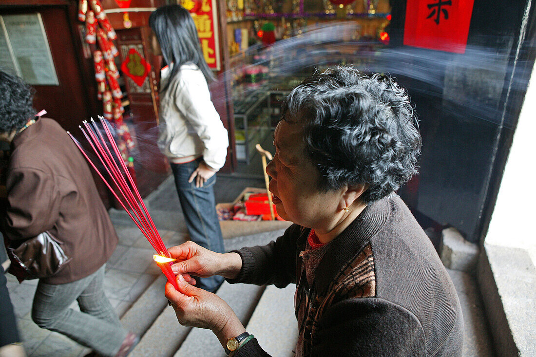 pilgrim woman praying offering incense sticks, Jiuhuashan, Mount Jiuhua, mountain of nine flowers, Jiuhua Shan, Anhui province, China, Asia
