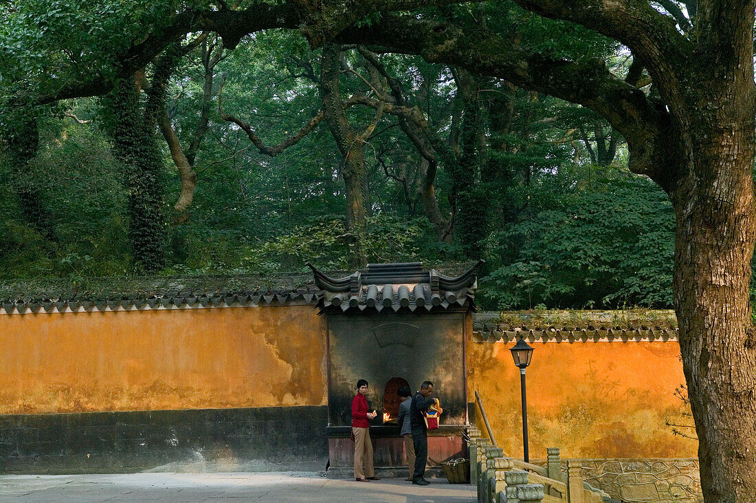 Zwei Menschen stehen vor der Mauer des Fayu Kloster auf der Klosterinsel Putuo Shan, Provinz Zhejiang, China, Asien