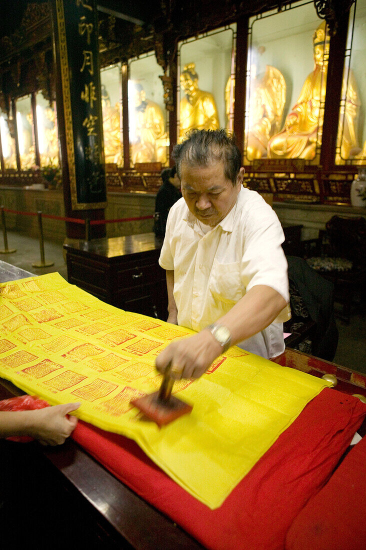 Älterer Mann stempelt Spendenquittung für Pilger, Puji Si Kloster, Klosterinsel Putuo Shan, Provinz Zhejiang, China, Asien