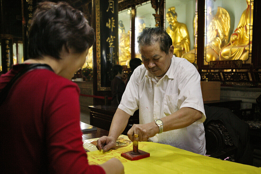 for a donation the pilgrims get a block print of the temple's name on their yellow bag, offical seal, Buddhist Island of Putuo Shan near Shanghai, Zhejiang Province, East China Sea, China, Asia