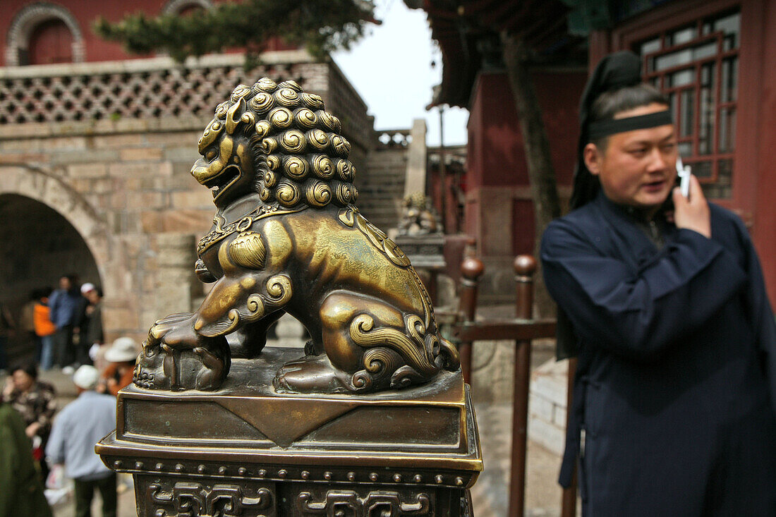 Mönch mit Handy, Taishan,Taoistischer Mönch mit Handy, Vorhof des Tempel der Azurblauen Wolke, Löwen Wächter, Taishan, Provinz Shandong, Taishan, Provinz Shandong, UNESCO Weltkulturerbe, China, Asien