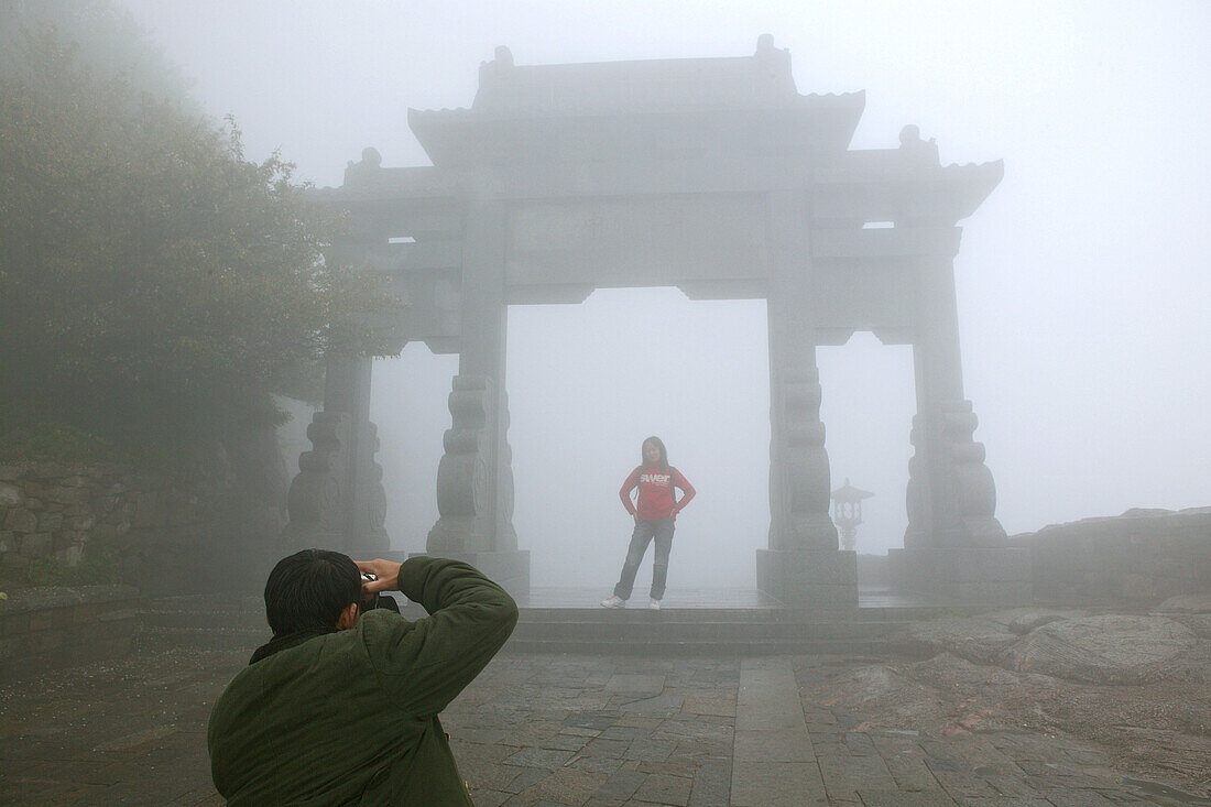 pilgrims, tourists in rain capes, entrance Bixia Si temple in fog, Tai Shan, Shandong province, Taishan, Mount Tai, World Heritage, UNESCO, China, Asia