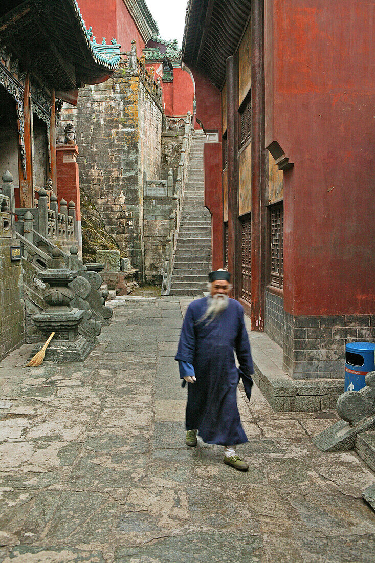Elderly taoist monk in an alleyway in the village Wudang Shan, Taoist mountain, Hubei province, Mount Wudang, UNESCO world cultural heritage site, birthplace of Tai chi, China