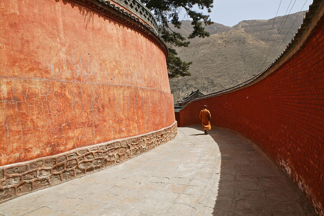 Monk walking to Pusa Ding Summit, high walls of the monastery, Xiantong Monastery, Wutai Shan, Five Terrace Mountain, Buddhist Centre, town of Taihuai, Shanxi province, China