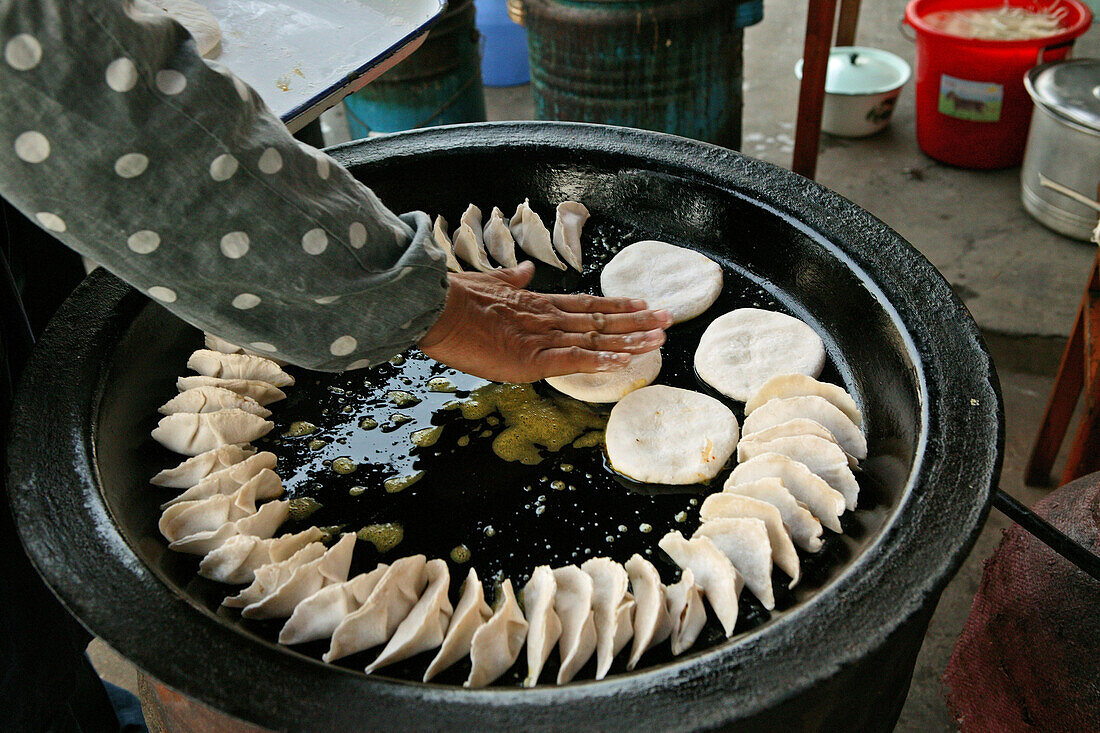 Jiaozi, cook turning fried Chinese ravioli, Chinese food, China