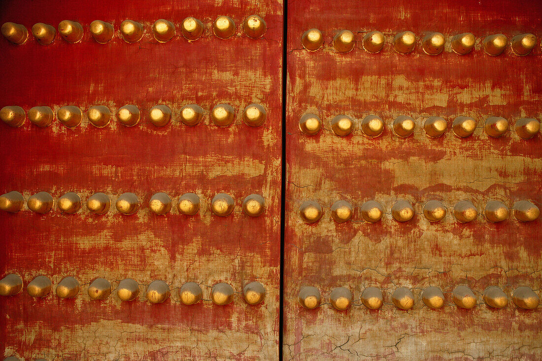 Close up of a temple door, double red gate with round yellow decorations, China