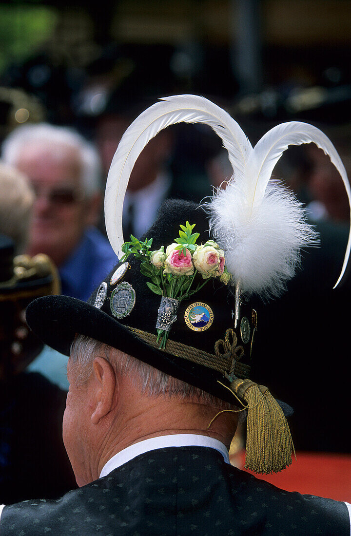 Man in traditional dress from the back with traditional hat and feather in a beer garden, pilgrimage to Raiten, Schleching, Chiemgau, Upper Bavaria, Bavaria, Germany