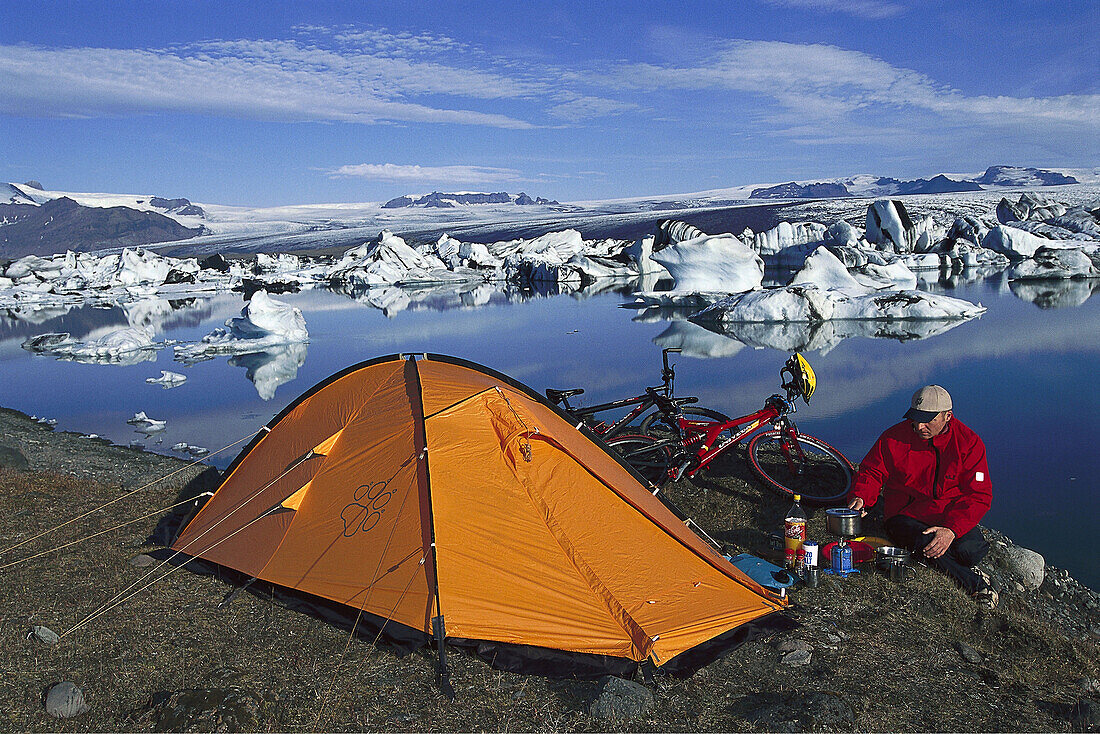 Mountainbiker am Zelt beim Kochen, Zelten, Jökulsarlon, Gletschersee, Island