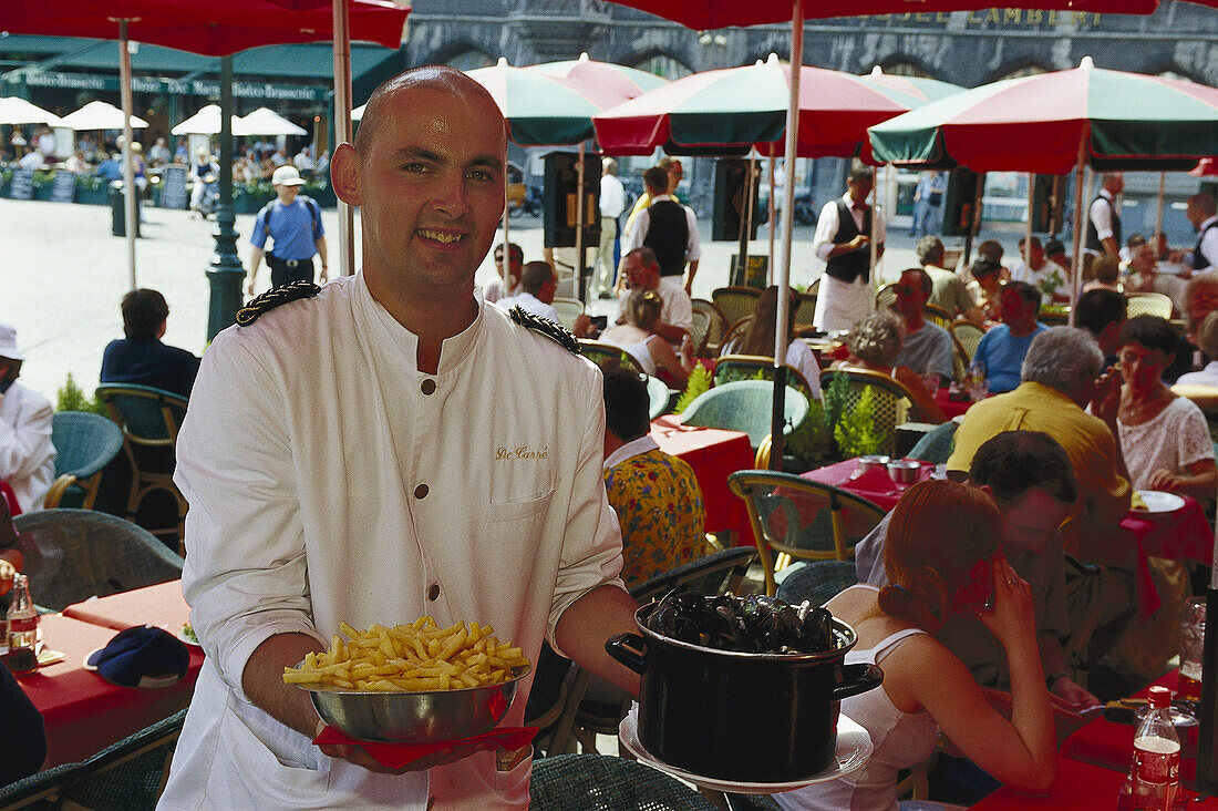 Waiter at a restaurant at the market square, Bruges, Flanders, Belgium, Europe