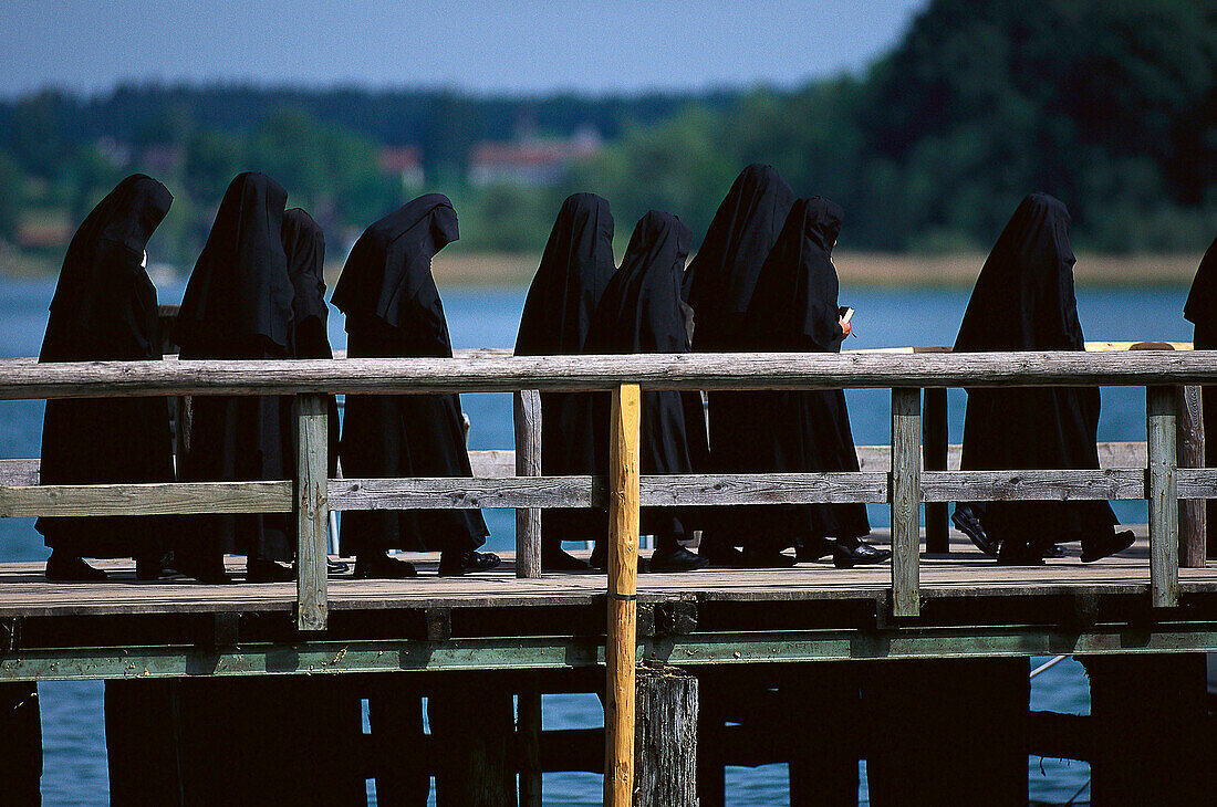 Benedictine nuns on jetty at lake Chiemsee, Frauenchiemsee, Bavaria, Germany