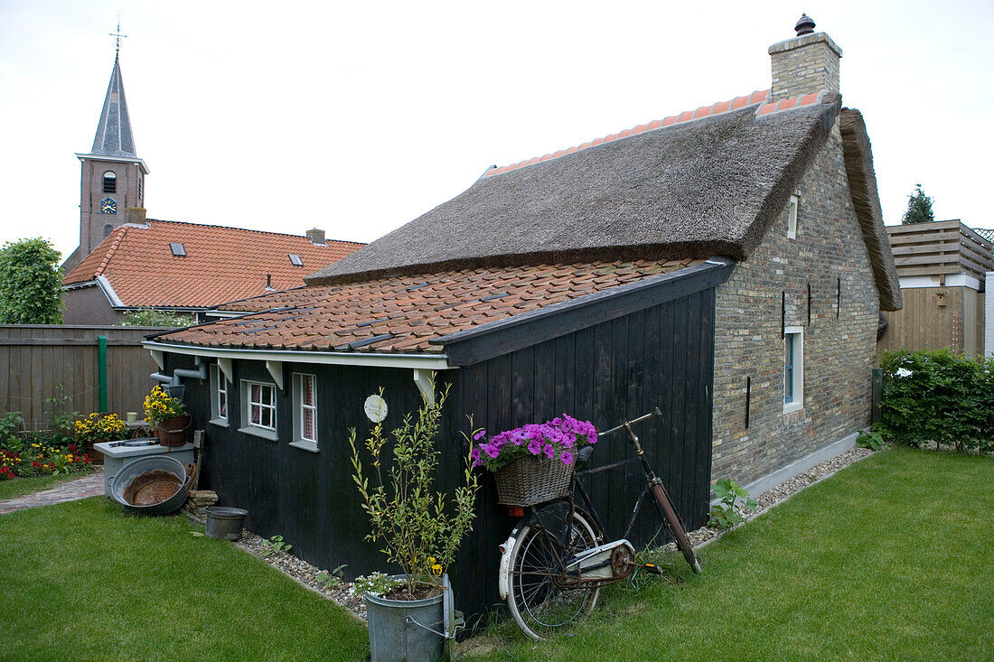 Idyllisches, kleines Häuschen und Fahrrad mit Blumen, Earnewald, Friesische Seen, Niederlande