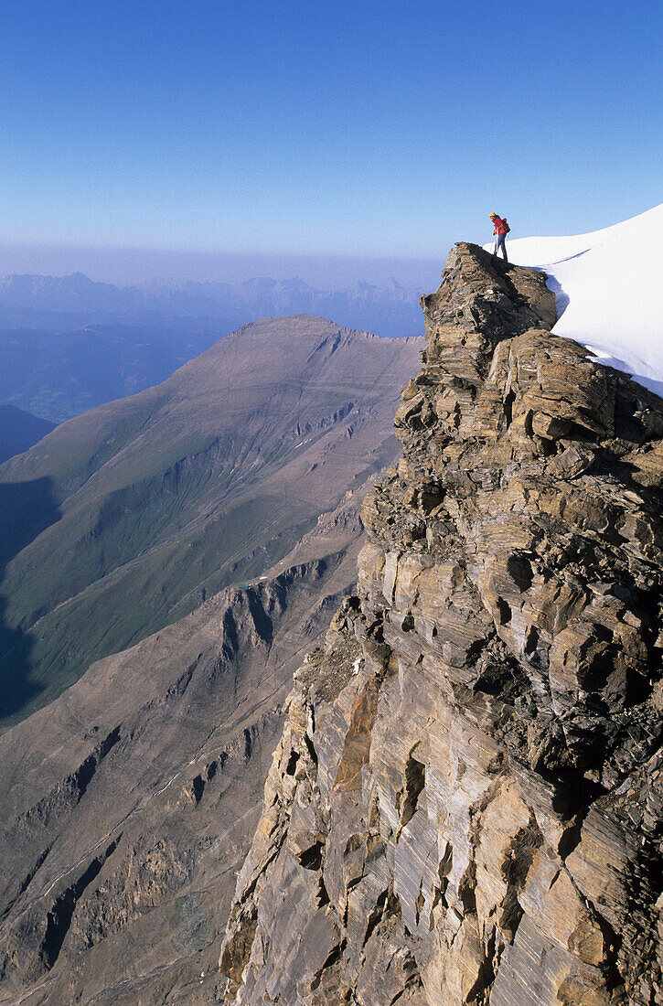 Mountaineer on the edge of the Glockerin cliff, Großglockner range, Hohe Tauern, Salzburg, Austria