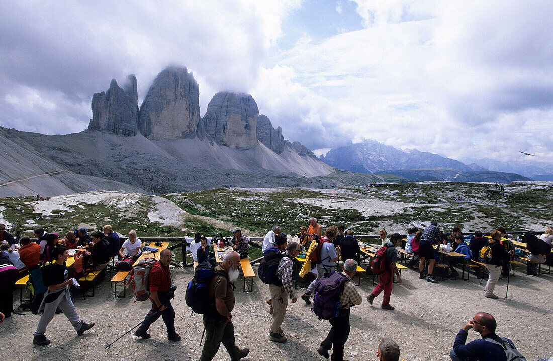 Drei Zinnen Hut with mountaineers on the terrasse and view to the Drei Zinnen, Dolomites, South Tyrol, Alto Adige, Italy