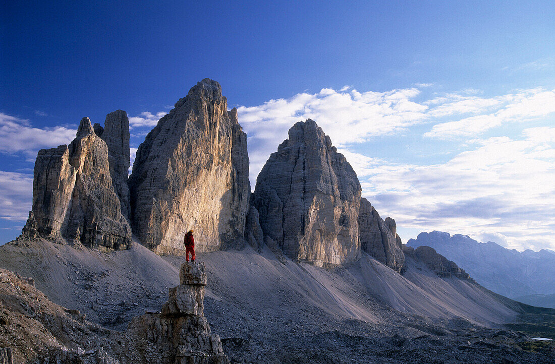 Mountaineer on a pinnacle in front of Drei Zinnen, Dolomites, South Tyrol, Italy