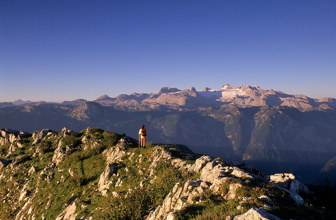 Bergsteiger am Gipfelgrat des Sarstein mit Ausblick auf die zentrale Dachsteingruppe mit Hohem Dachstein, Dachsteingruppe, Oberösterreich, Österreich