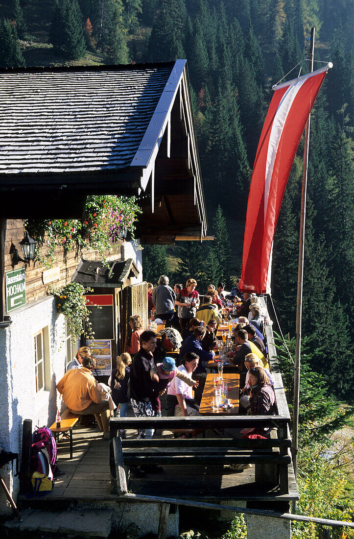 Alm with guests sitting on the sunny terrace, Chiemgau, Bavarian Alps, Salzburg, Austria