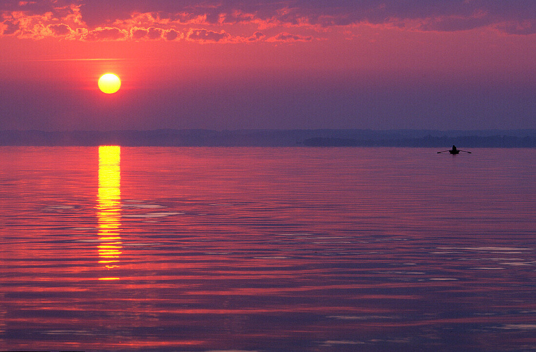 Sunrise at lake Chiemsee with sun and fishing boat, Prien, Chiemgau, Upper Bavaria, Bavaria, Germany