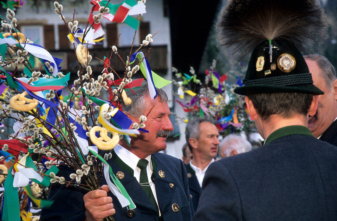 Männer in Tracht mit Gamsbart am Hut und geschmückten Palmzweigen, Palmenweihe Palmsonntag, Reit im Winkl, Chiemgau, Oberbayern, Bayern, Deutschland