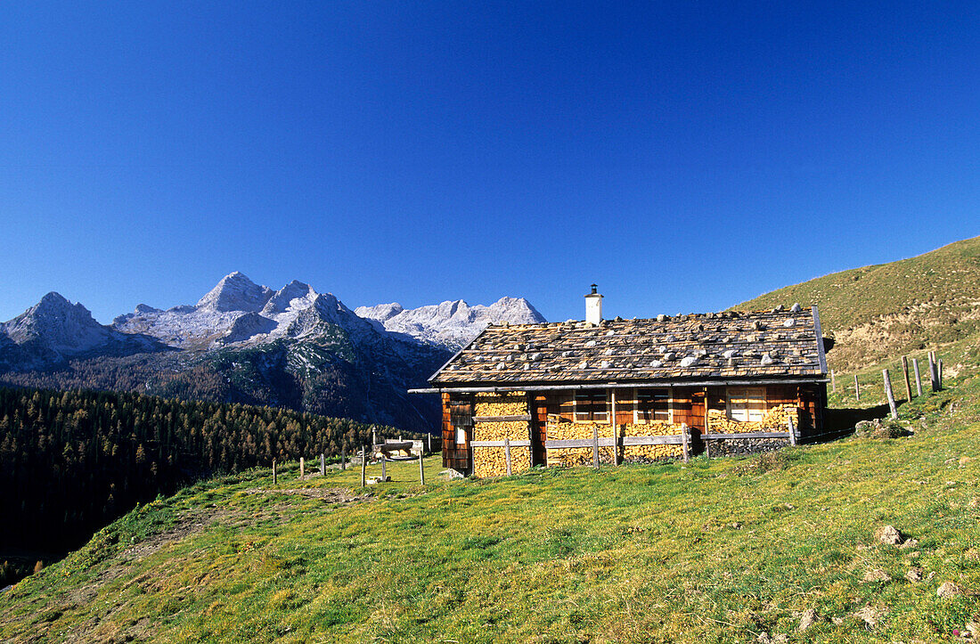 Traditional alpine hut with shingle roof in front of Leoganger Steinberge and Birnhorn, Kallbrunnalm, Berchtesgaden range, Salzburg, Austria