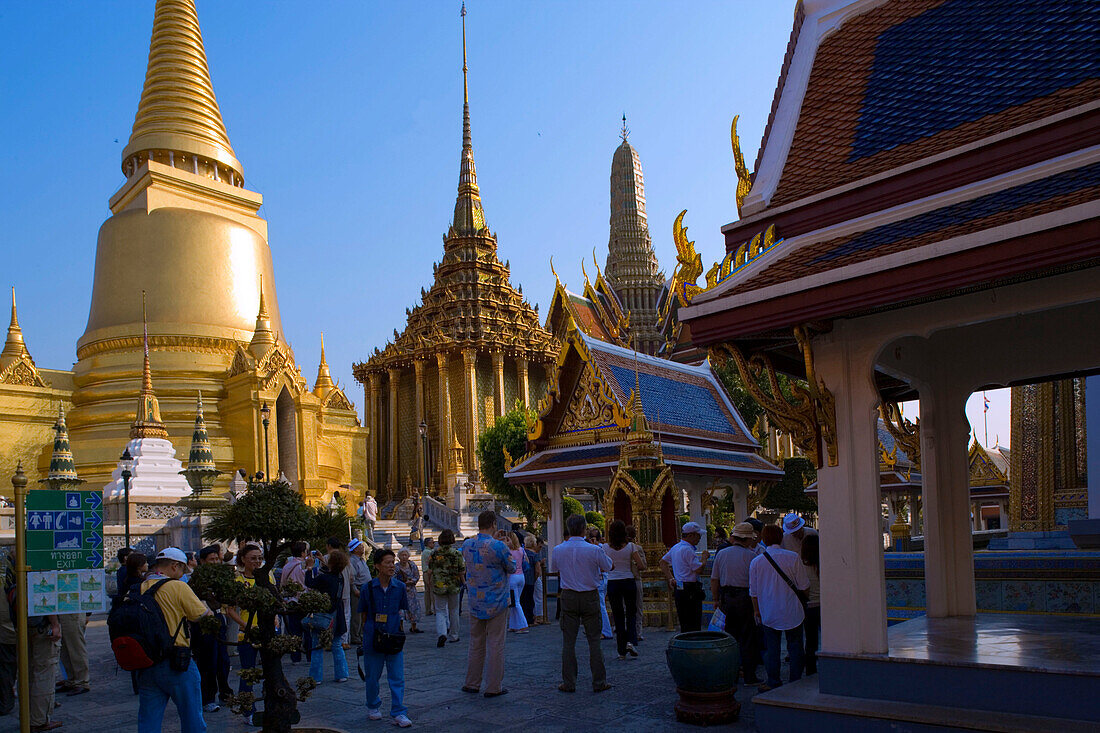 Group of tourists visiting the Wat Phra Kaew, the most important Buddhist temple of Thailand, Phra Sri Rattana Chedi and Phra Mondop, the library in background, Ko Ratanakosin, Bangkok, Thailand