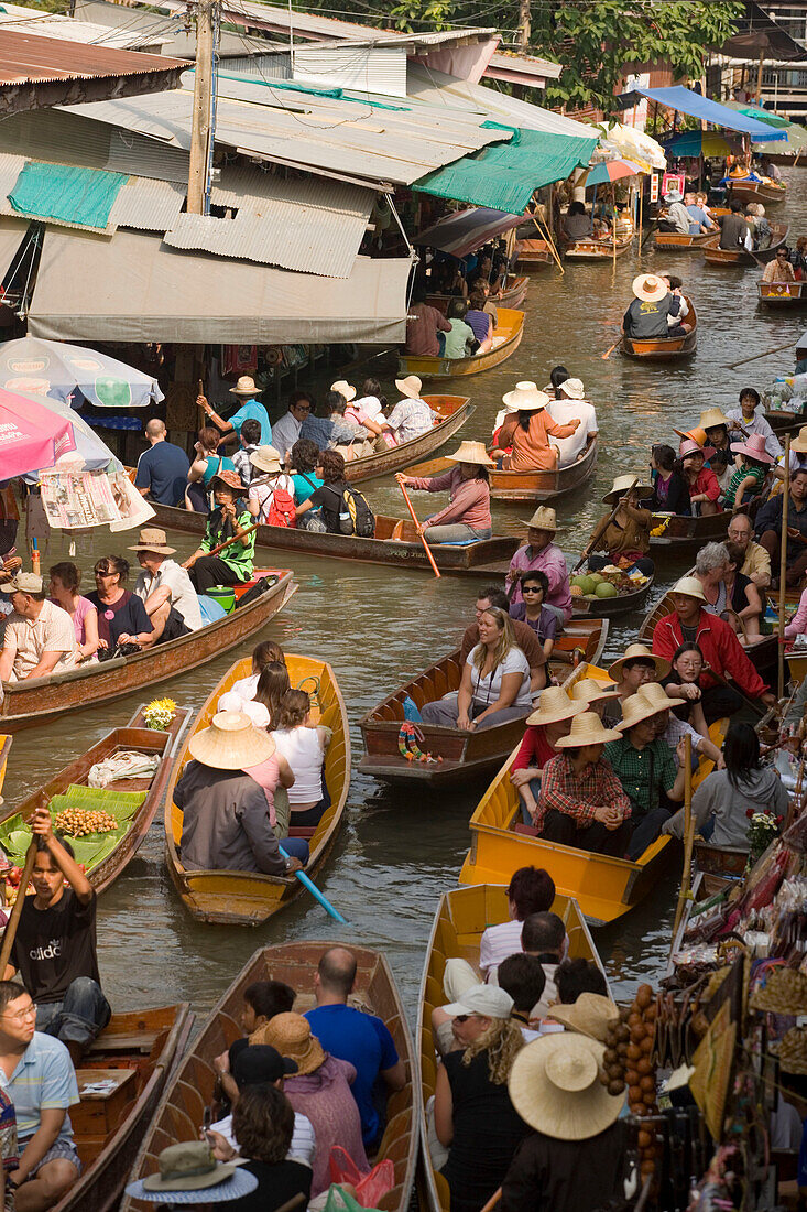 Tourists in a wooden boat visiting the Floating Market, Damnoen Saduak, near Bangkok, Ratchaburi, Thailand