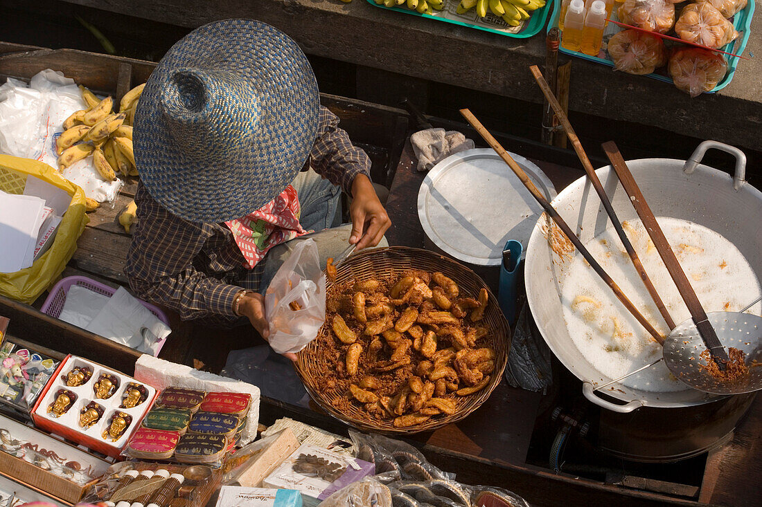 Frau verkauft Essen und Souvenirs auf dem Schwimmenden Markt, Damnoen Saduak, bei Bangkok, Ratchaburi, Thailand