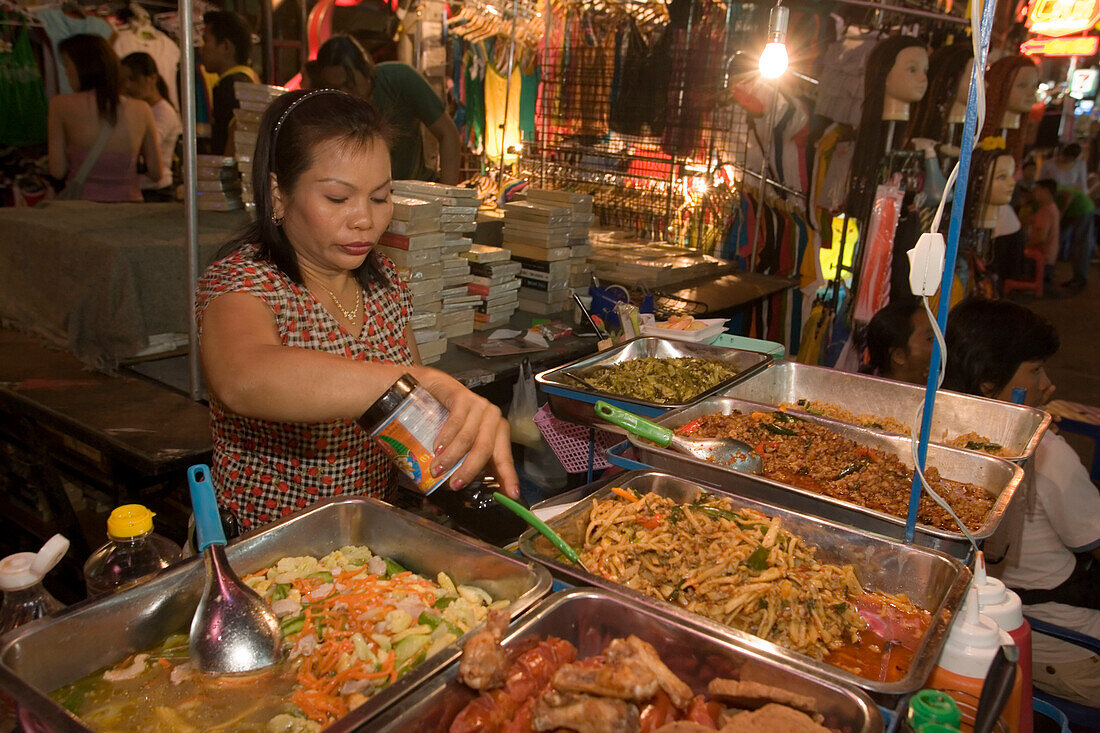 Woman preparing fresh food at a  stand at Th Khao San Road in the evening, Banglamphu, Bangkok, Thailand